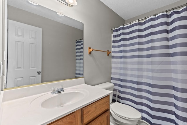 bathroom featuring a textured ceiling, vanity, and toilet