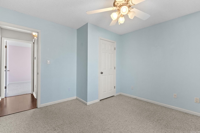 unfurnished bedroom with baseboards, ceiling fan, a textured ceiling, and light colored carpet