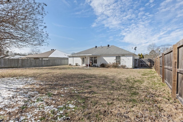 rear view of property with a fenced backyard and a lawn