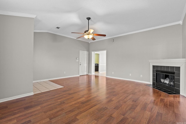 unfurnished living room featuring ornamental molding, visible vents, a fireplace, and wood finished floors