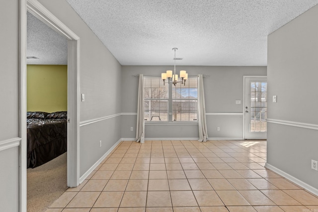 unfurnished dining area with a healthy amount of sunlight, an inviting chandelier, and light tile patterned flooring