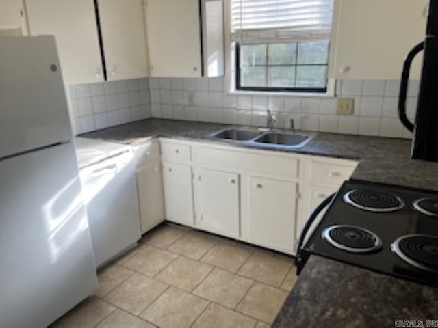 kitchen with white appliances, a sink, white cabinets, backsplash, and dark countertops