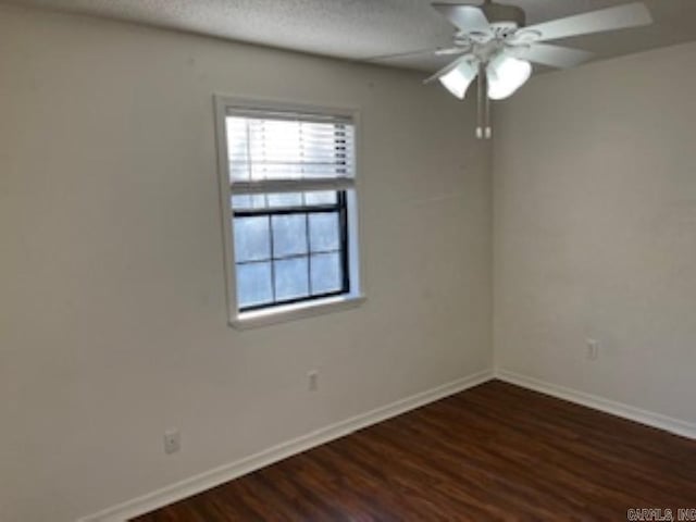 unfurnished room featuring dark wood-style floors, a textured ceiling, baseboards, and a ceiling fan