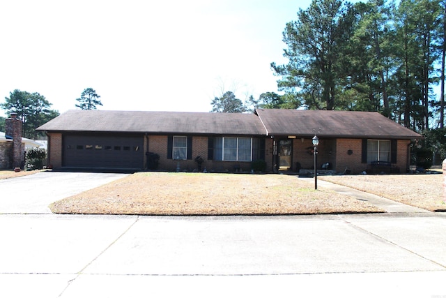 ranch-style home with a garage, driveway, and brick siding