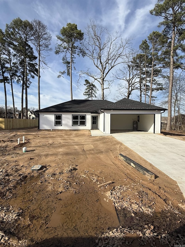 view of front of home with concrete driveway and fence