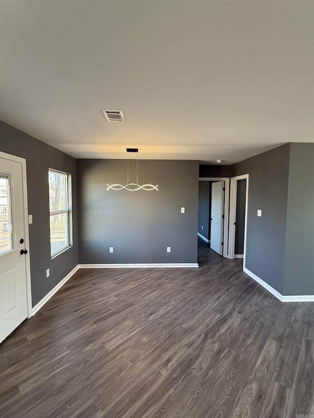 interior space with a notable chandelier, dark wood finished floors, visible vents, and baseboards