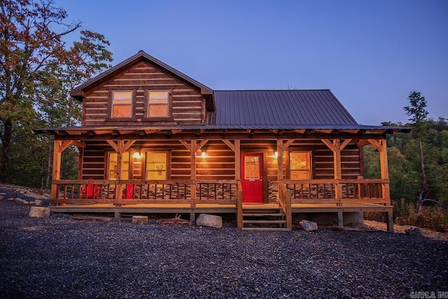 log cabin featuring covered porch and metal roof