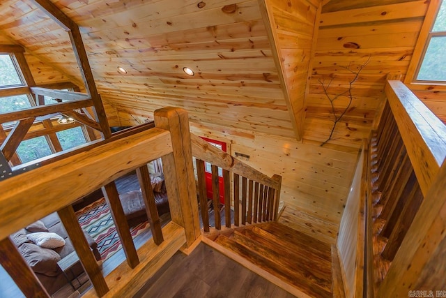 staircase with wooden ceiling, wooden walls, and wood finished floors