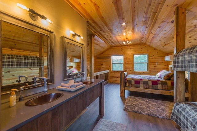 bedroom featuring wooden walls, lofted ceiling, hardwood / wood-style flooring, wood ceiling, and a sink