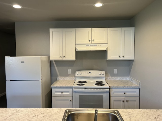 kitchen with recessed lighting, white cabinets, a sink, white appliances, and under cabinet range hood