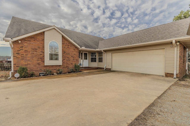 ranch-style home with a shingled roof, brick siding, driveway, and an attached garage