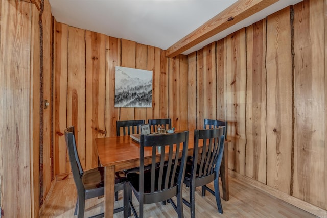 dining room featuring wood finished floors and wooden walls