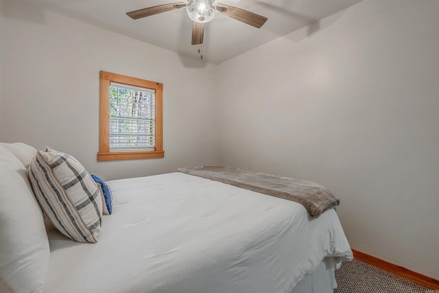 bedroom with ceiling fan, baseboards, and wood finished floors