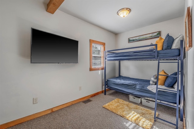 bedroom with beam ceiling, carpet flooring, visible vents, and baseboards