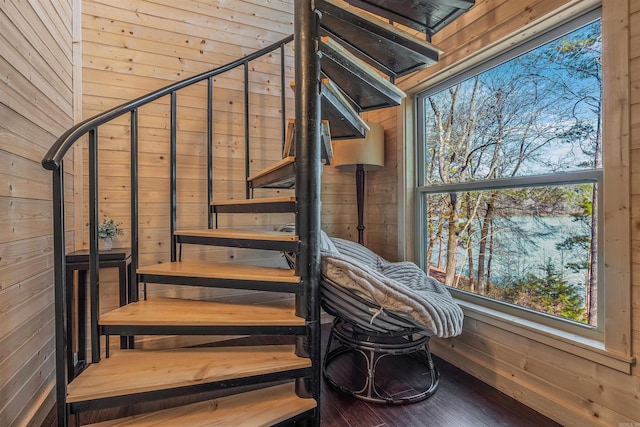 stairway featuring wood walls