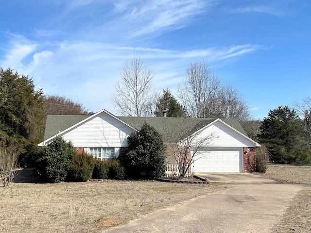 view of side of property with a garage, concrete driveway, brick siding, and roof with shingles