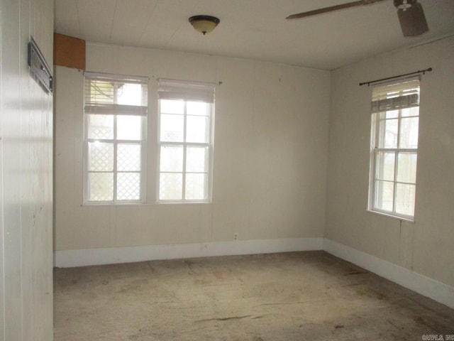 empty room featuring a ceiling fan, light colored carpet, and baseboards