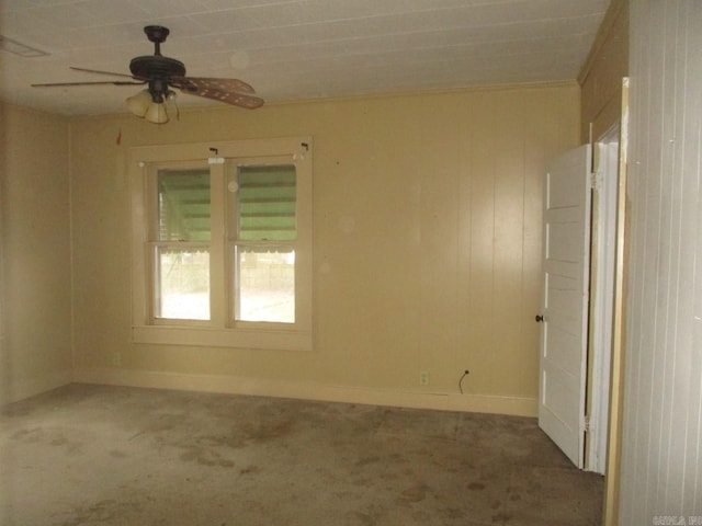 carpeted empty room with baseboards, ornamental molding, and a ceiling fan