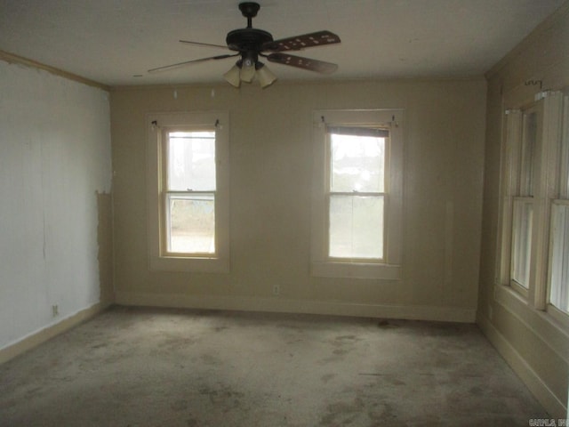 empty room featuring light carpet, a ceiling fan, and baseboards