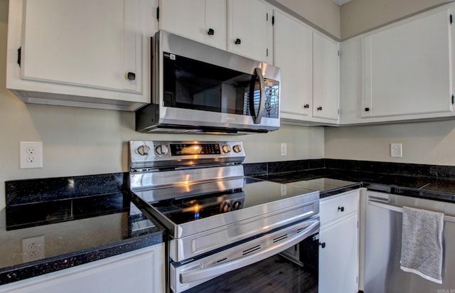 kitchen featuring appliances with stainless steel finishes, white cabinets, and dark stone counters