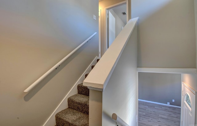 stairway featuring baseboards and wood finished floors