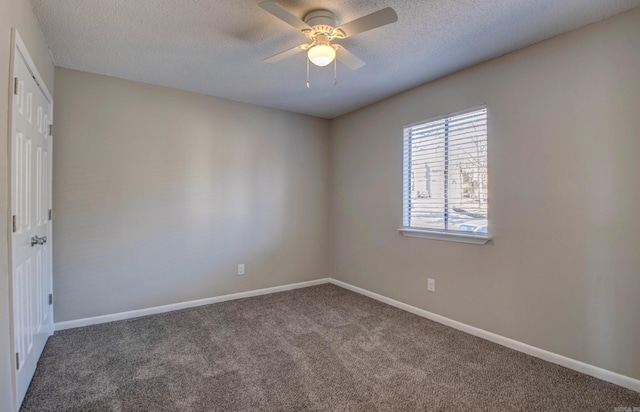 carpeted spare room with a ceiling fan, a textured ceiling, and baseboards