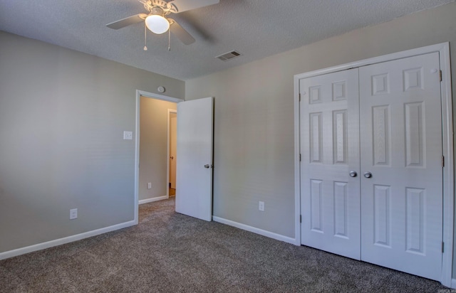 unfurnished bedroom featuring a textured ceiling, visible vents, baseboards, a closet, and dark carpet