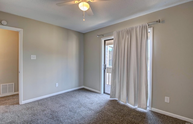 empty room featuring carpet floors, visible vents, baseboards, and a ceiling fan