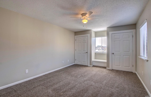 unfurnished bedroom featuring a textured ceiling, carpet floors, a ceiling fan, and baseboards