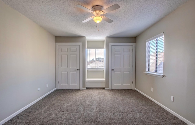 unfurnished bedroom with a ceiling fan, carpet flooring, a textured ceiling, and baseboards