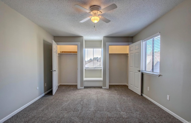 unfurnished bedroom featuring multiple closets, baseboards, multiple windows, and carpet flooring