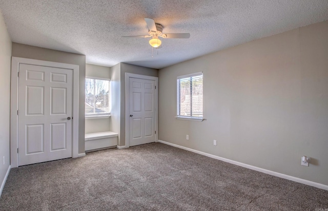 unfurnished bedroom with a ceiling fan, carpet, baseboards, and a textured ceiling