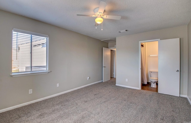 unfurnished bedroom with carpet, visible vents, connected bathroom, a textured ceiling, and baseboards