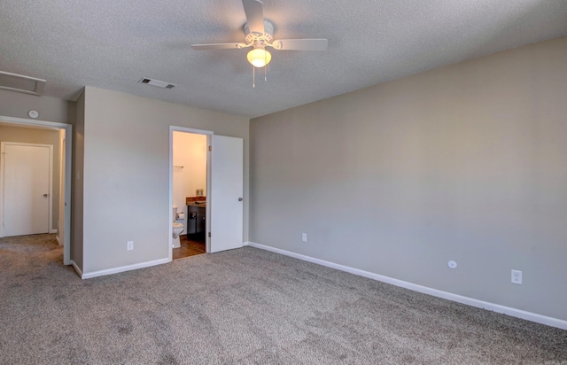 unfurnished bedroom featuring carpet floors, visible vents, attic access, a textured ceiling, and baseboards