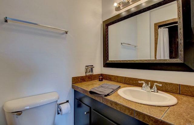 bathroom with a shower with shower curtain, vanity, and toilet