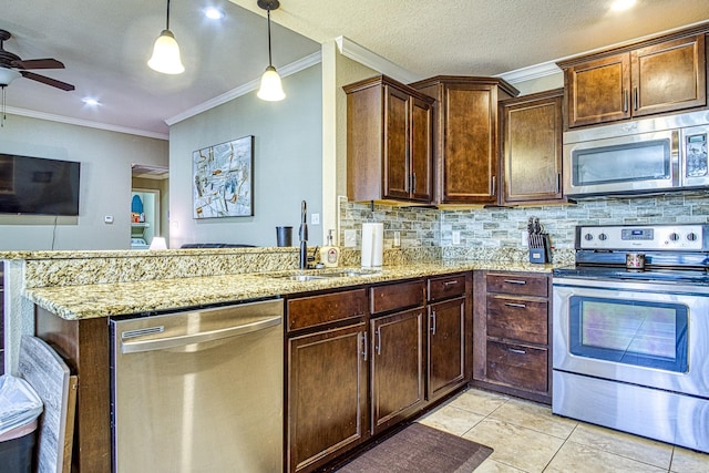 kitchen featuring a peninsula, appliances with stainless steel finishes, pendant lighting, and a sink