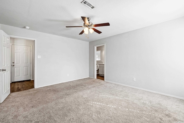 unfurnished bedroom with visible vents, dark carpet, a textured ceiling, and baseboards