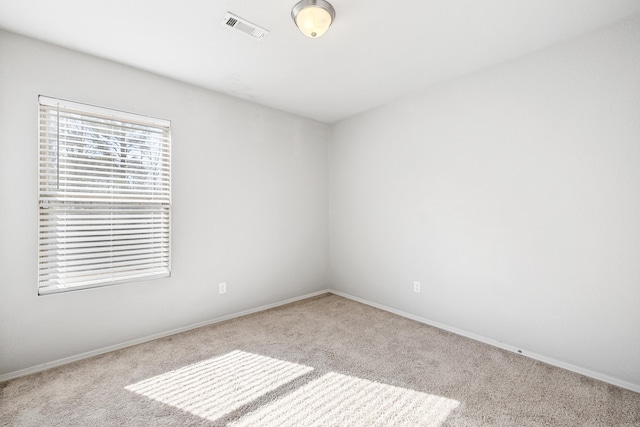 empty room with light carpet, baseboards, and visible vents