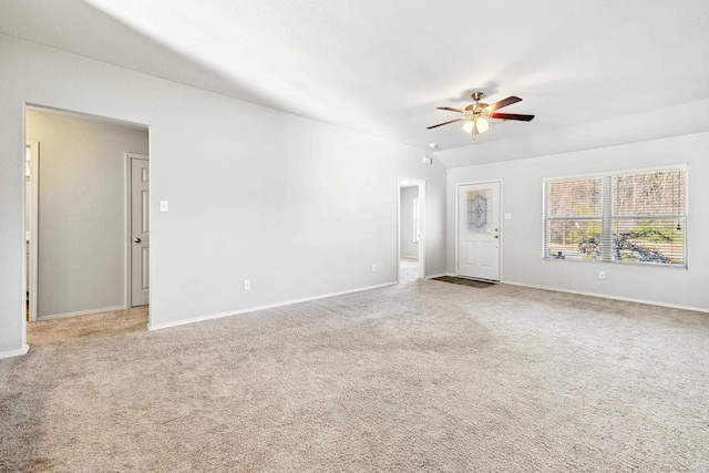 spare room featuring light carpet, ceiling fan, and baseboards