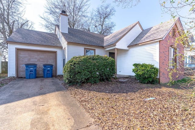 view of front of property with a garage, driveway, a chimney, and roof with shingles