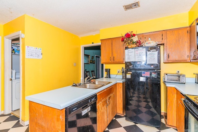 kitchen featuring a sink, black appliances, light floors, and light countertops