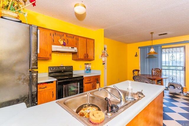 kitchen featuring under cabinet range hood, light countertops, tile patterned floors, black appliances, and decorative light fixtures