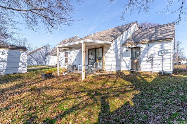 back of house featuring a porch, cooling unit, and a lawn