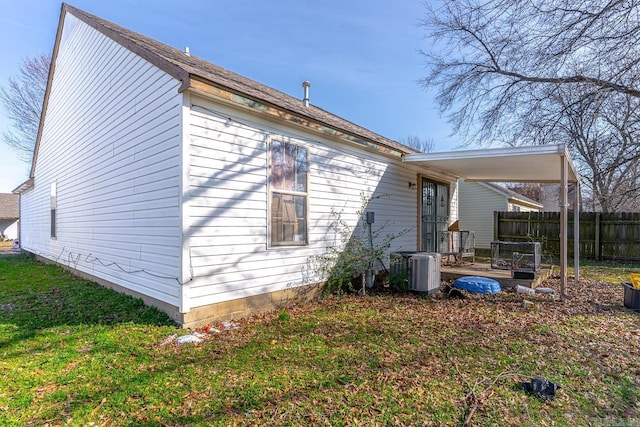 view of home's exterior featuring a yard, central AC, and fence