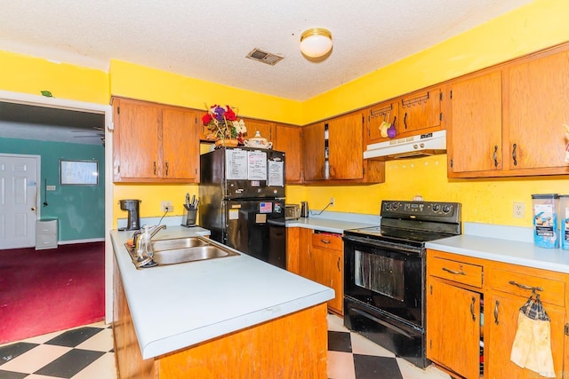 kitchen with under cabinet range hood, a sink, light countertops, black appliances, and light floors