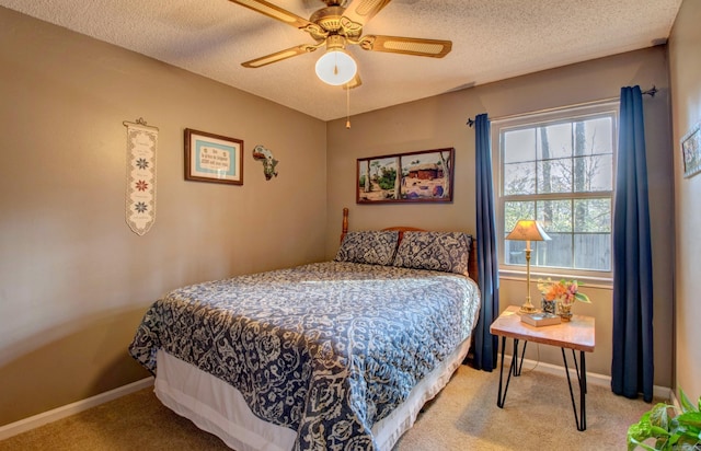 bedroom featuring a ceiling fan, baseboards, a textured ceiling, and light colored carpet