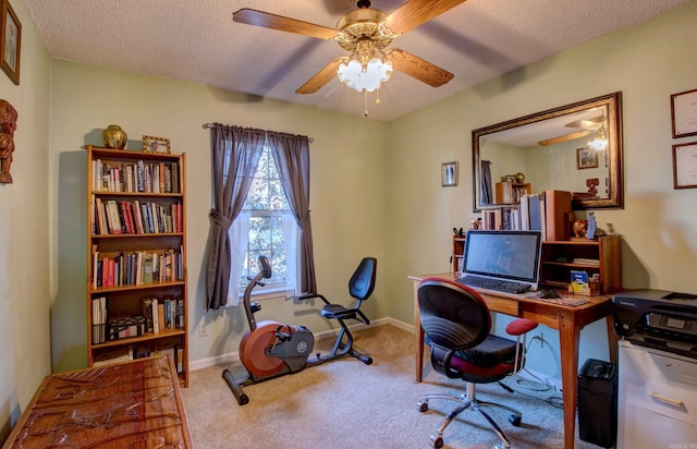 office area featuring ceiling fan, baseboards, a textured ceiling, and light colored carpet