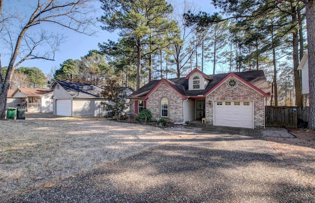 view of front of property with an attached garage, fence, and brick siding