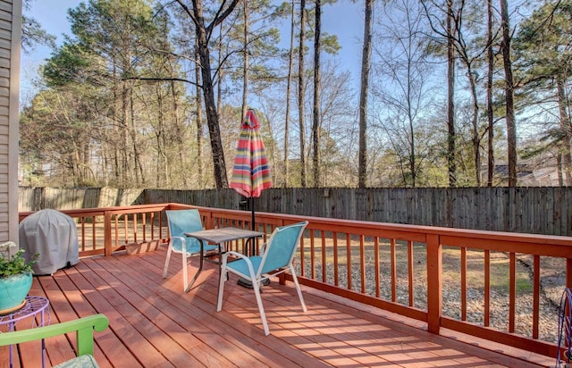 wooden terrace with a fenced backyard