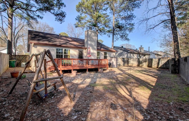 rear view of house with a fenced backyard, a chimney, and a wooden deck